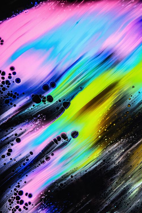 Swirls of pink, blue and yellow liquid with small bubbles